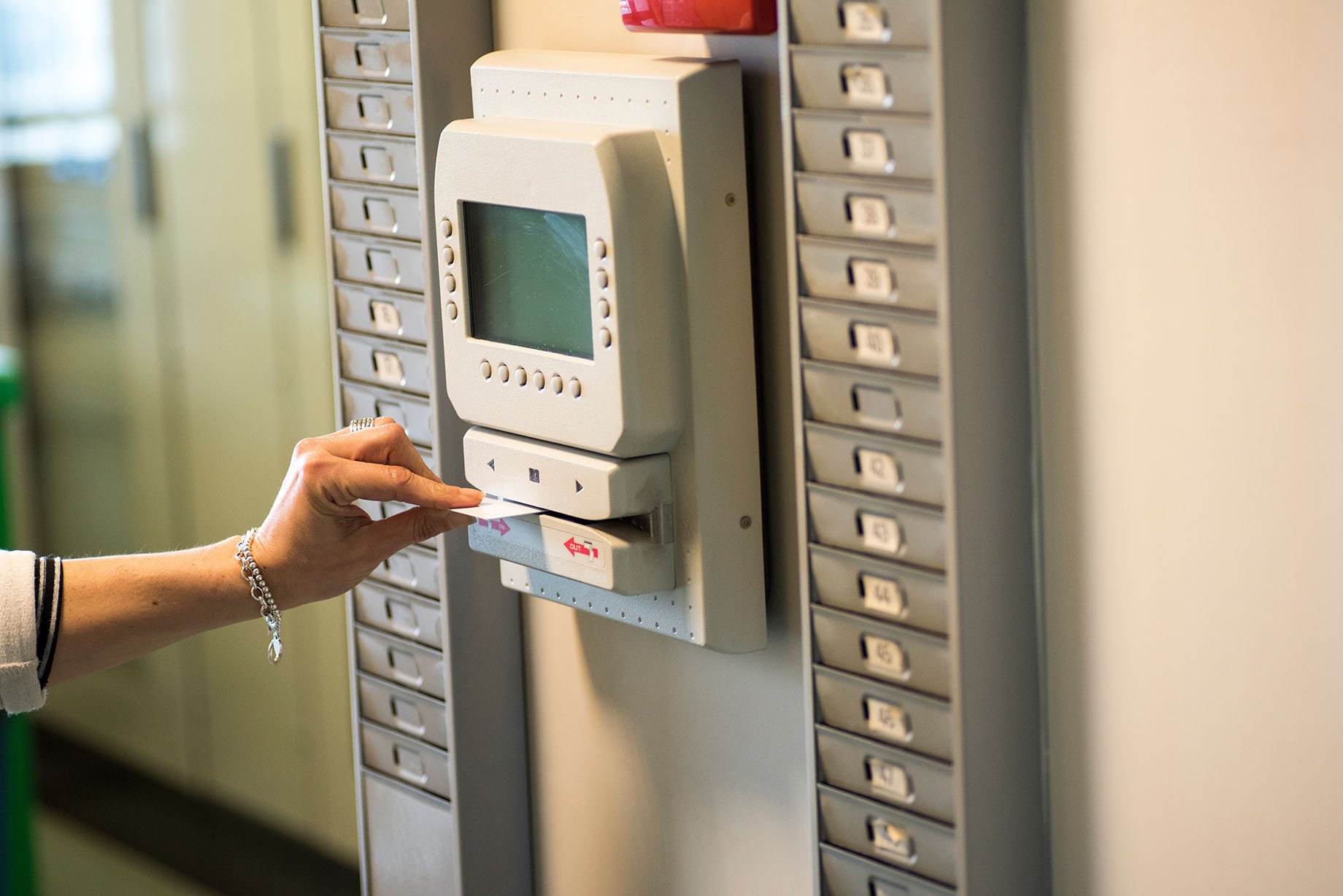 an employee swiping an id in a time clock