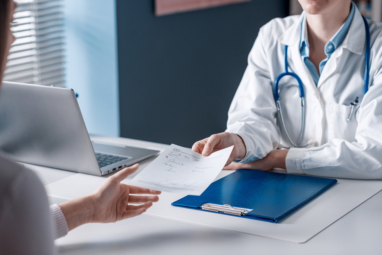 Doctor giving a prescription to a patient.