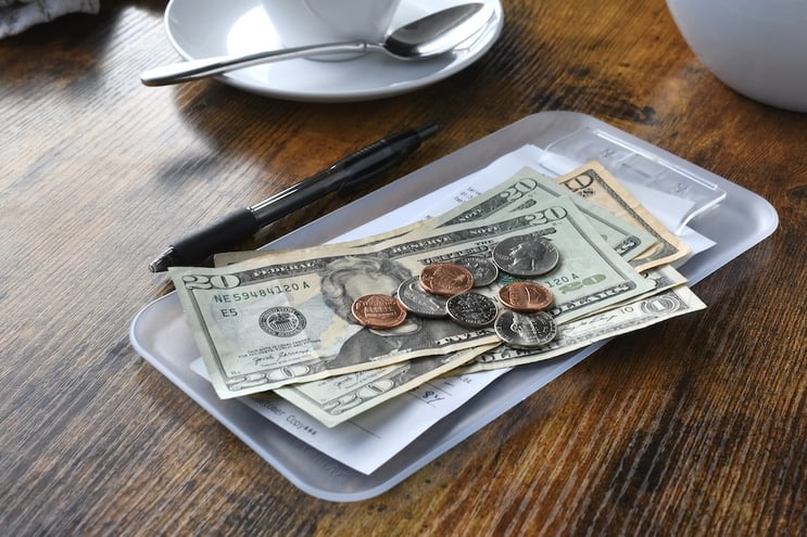 cash bills and coins in a tray on a table