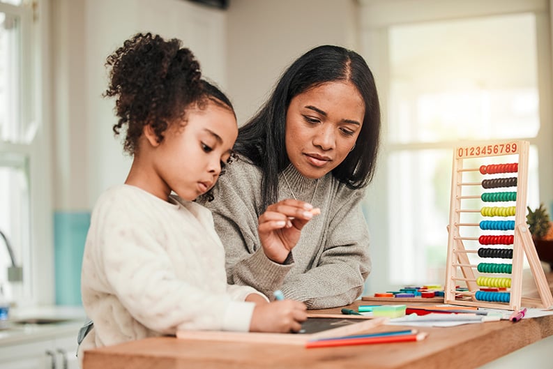 a working mom watches over her kid play with toys.