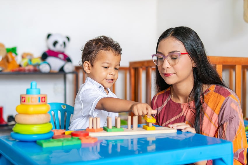 a mom and her child play at the table.