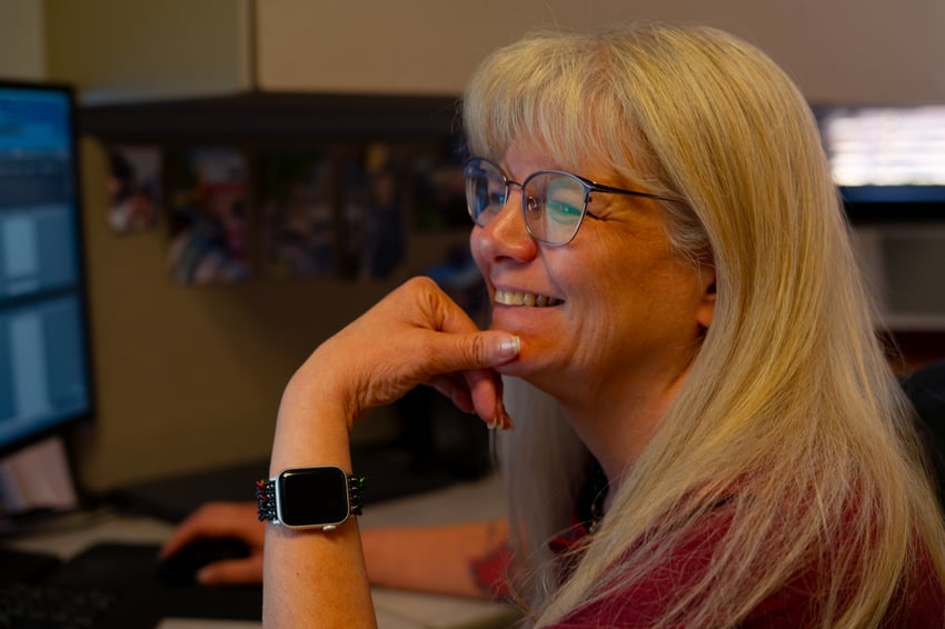 a woman looking at her computer and smiling
