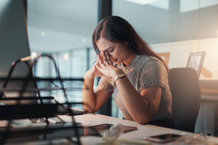 a-woman-sitting-at-her-desk-looking-frustrated