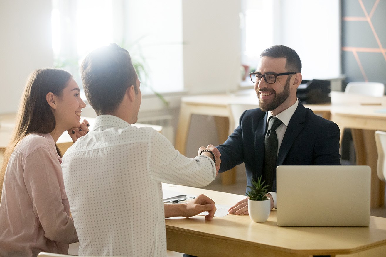 Smiling lawyer, realtor or financial advisor handshaking young couple thanking for advice, insurance broker or bank worker and millennial customers shake hands making deal, investment or taking loan.