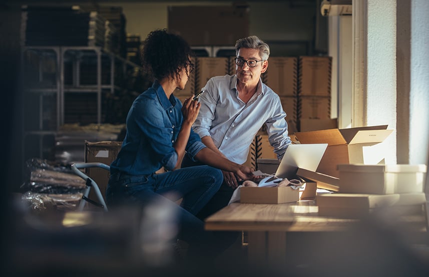 a man and a woman discussing shipping in a small business
