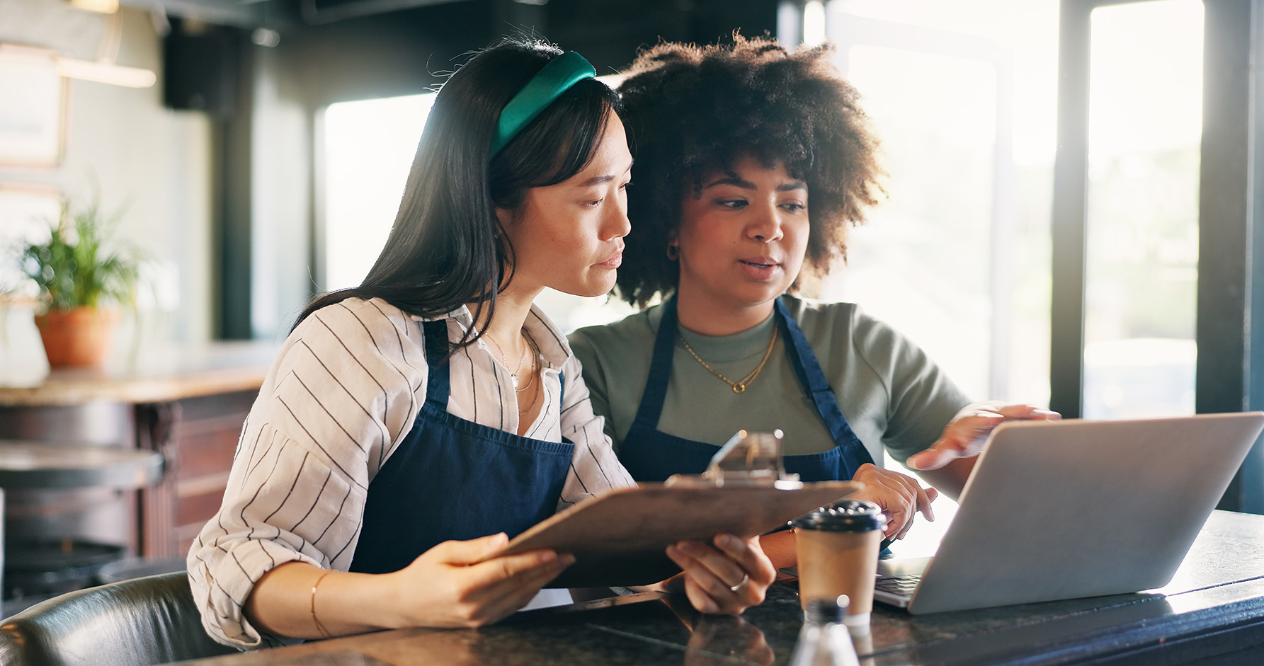 Women, waitress or manager with documents, computer and planning budget in a startup cafe.
