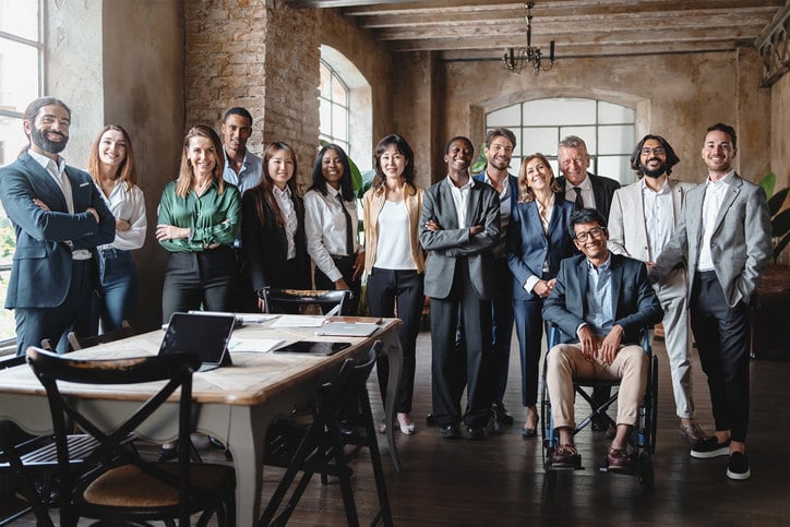 a-group-of-people-stand-together-in-an-office-and-pose-for-a-photo