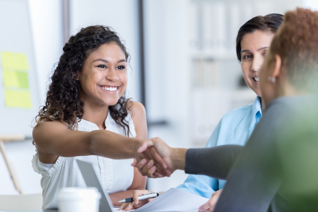 a woman shaking hands with a business guy.